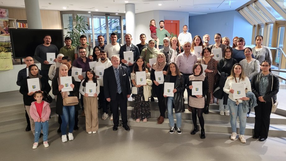 Gruppenfoto mit Menschen, die eine Urkunde in der Hand halten.