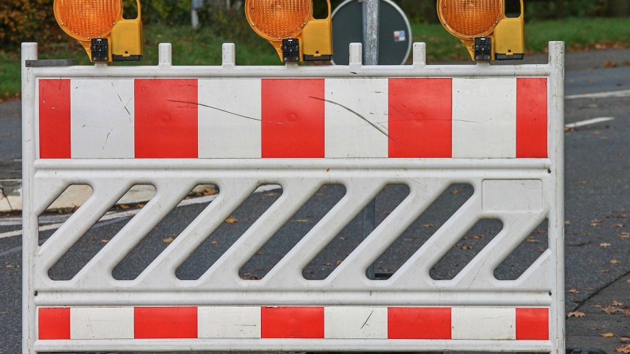 Rot-Weiße Straßenabsperrung mit gelben Warnleuchten. 