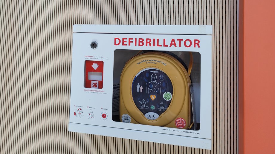 Ein Defibrillator in einem Kasten an einer Wand.