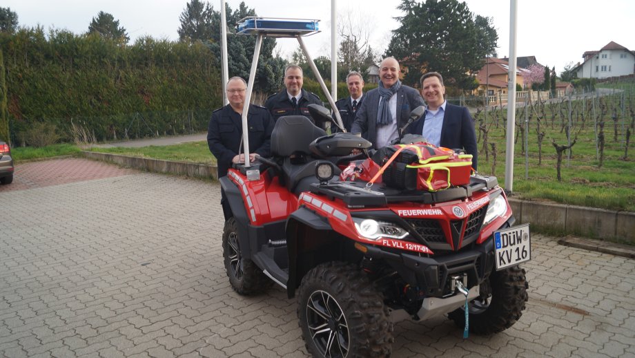 Fünf Männer stehen hinter einem Feuerwehr-Quad.